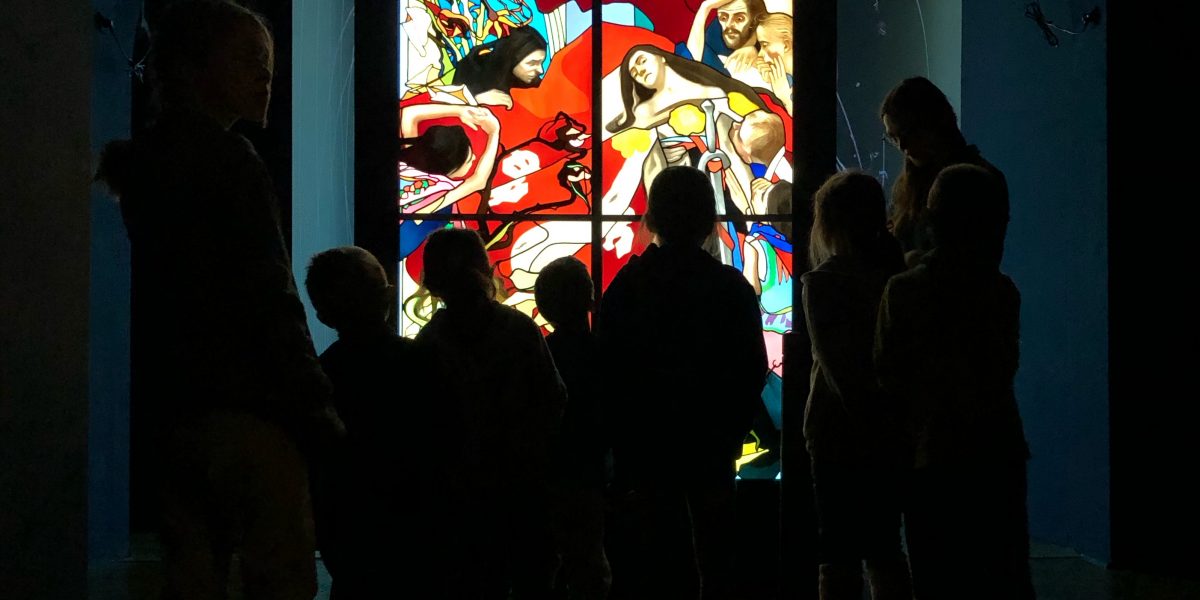 Grupa turystów podziwiająca witraż w Muzeum Witrażu w Krakowie
