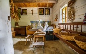 Wnętrze drewnianej chaty, drewniane meble, na ścianie święte obrazy