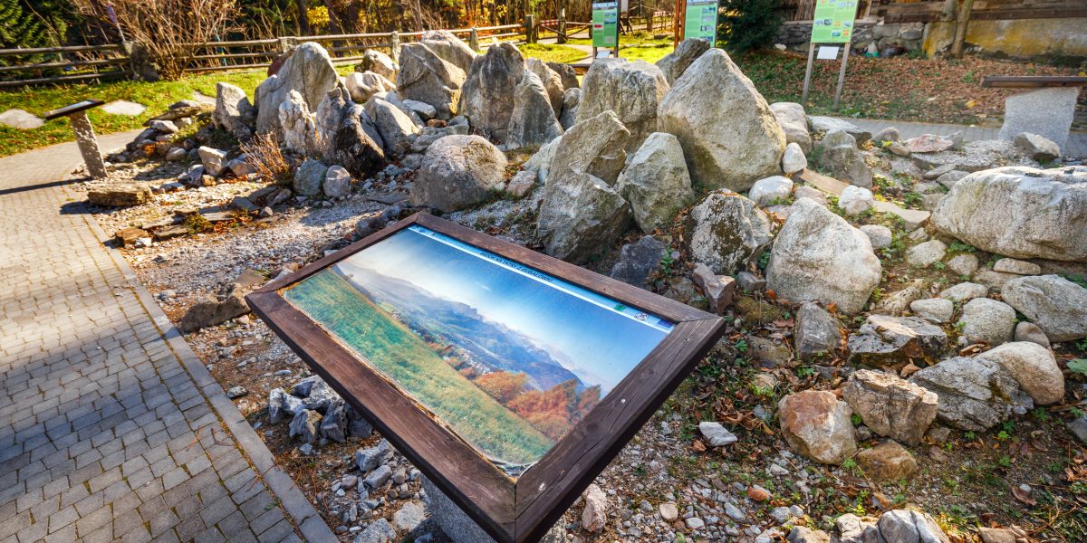 Zdjęcie panoramy gór umioeszcozne na stojaku, za nim kilkadziesiąt kamieni różnych kształtów i wielkości